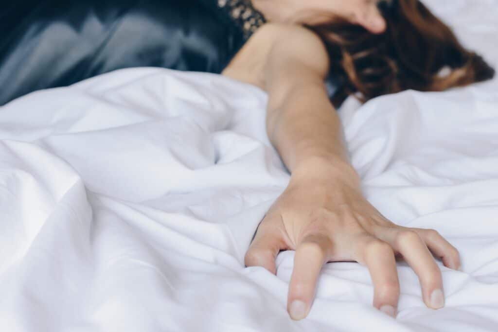 Uma mulher demostra estar sentindo prazer ao receber sexo oral.